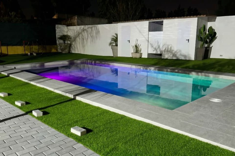 Diseño de piscina de obra con iluminación LED subacuática.