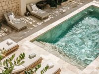 Piscina rodeada de tumbonas en un complejo residencial. Constructores especializados en agua mineralizada.