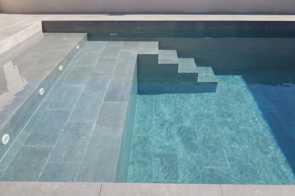 Piscina de obra con revestimiento de gres porcelánico.