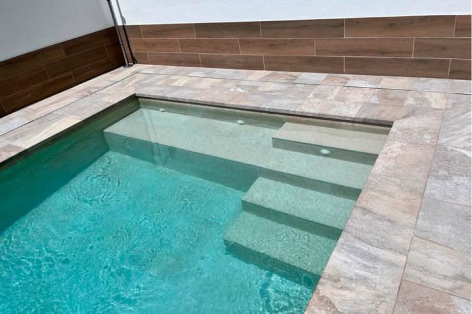 Piscina de obra con zona de playa y escaleras integradas en Murcia.