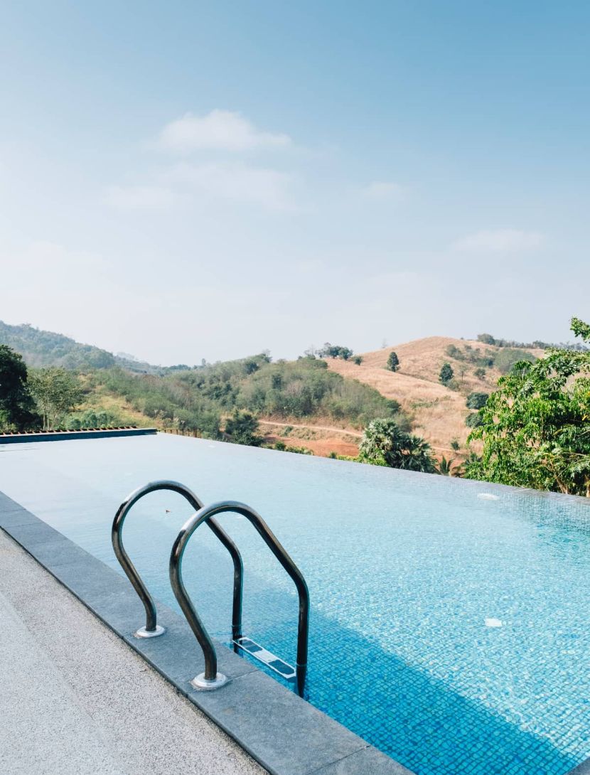 Piscina infinita con agua cristalina, borde desbordante y paisaje natural que transmite calma y bienestar